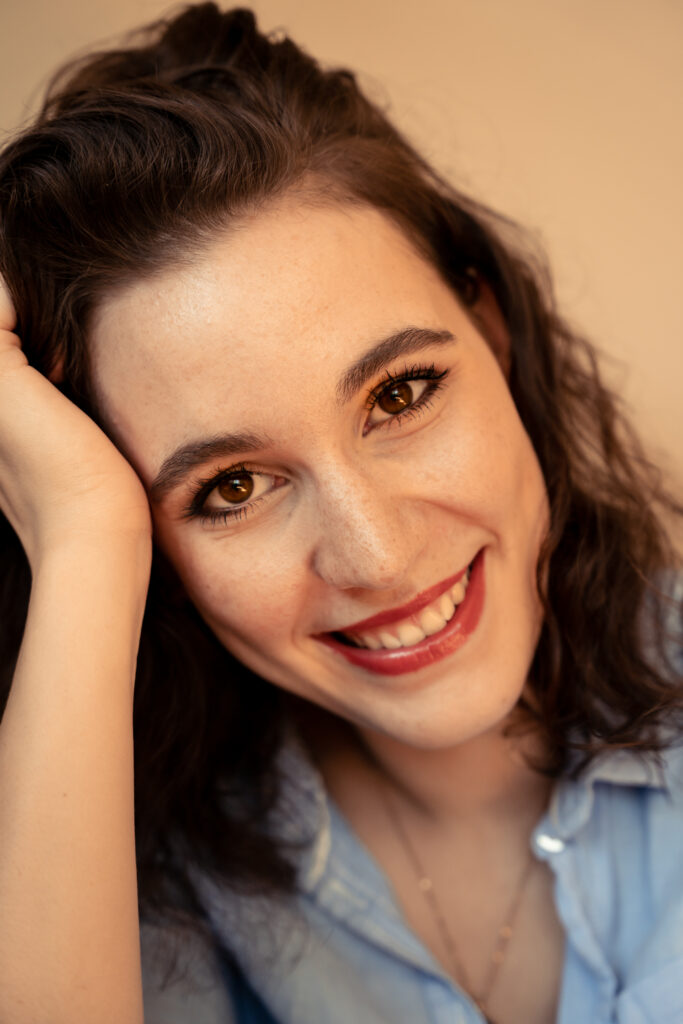 Portrait einer Frau mit dunklen Haaren die in die Kamera strahlt